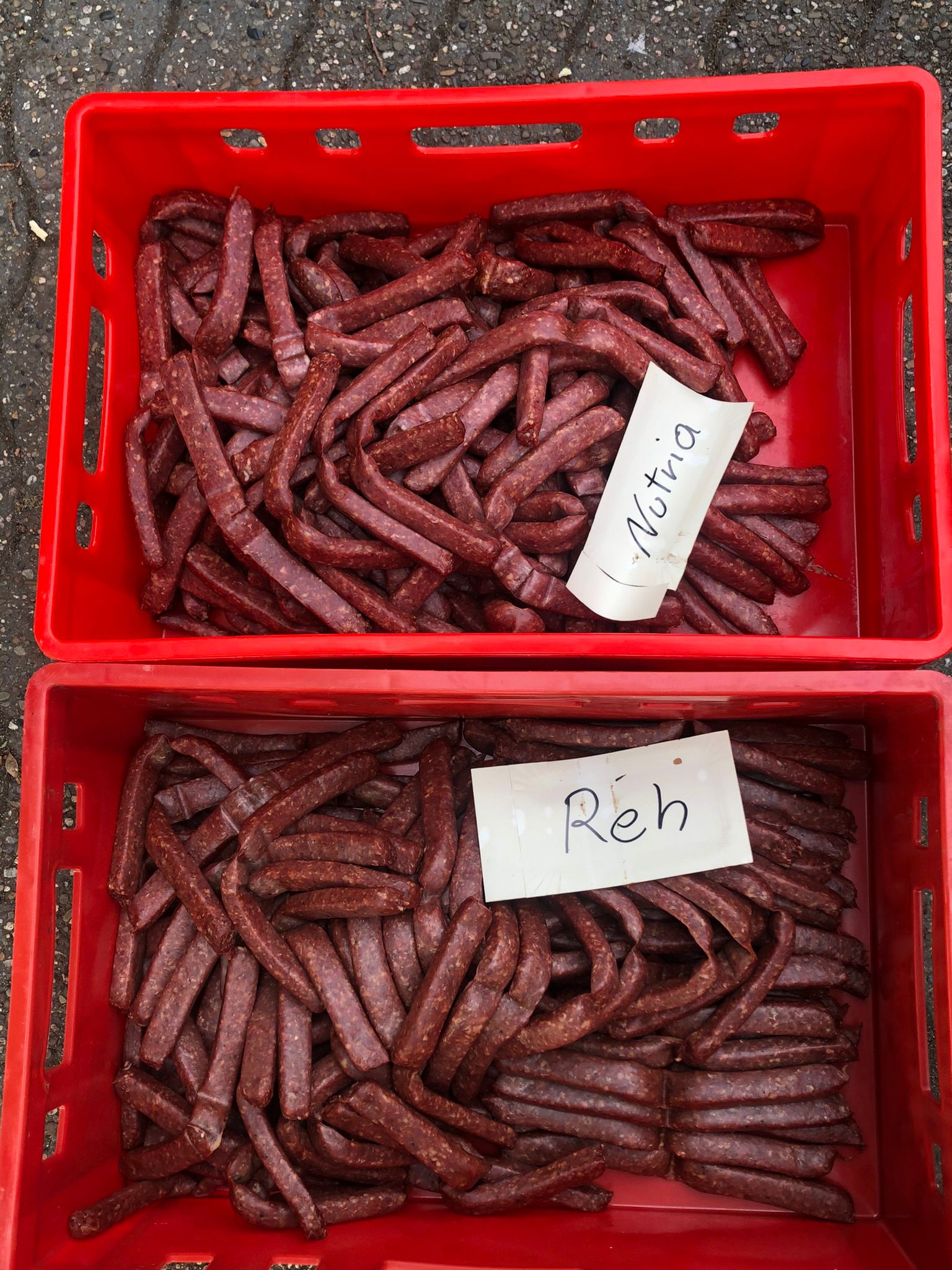 Geräucherte Landjäger in zwei roten E2-Kisten mit beigelegten Produktflyern